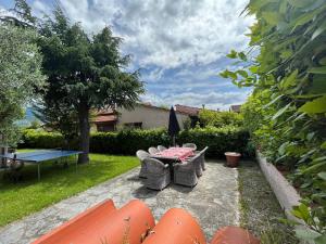 a patio with a table and chairs in a yard at GREAT PRIVATE VILLA for family beach holidays and cultural outings near Forte dei Marmi RECOMMENDED in Marina di Pietrasanta