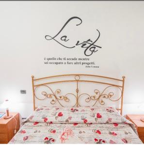 a bedroom with a bed with a sign on the wall at Casa vacanze Mimí in Cefalù