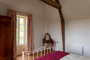1 dormitorio con cama y ventana en Chambres d'hôtes Château de Saint Etienne du Bois, en Saint-Étienne-du-Bois