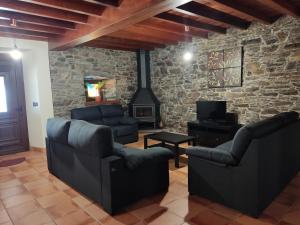 sala de estar con 2 sillas y chimenea en Casa rural con piscina, Cedeira, San Román en Cedeira