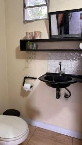 uma casa de banho com um lavatório e um WC em Amorada em Santo Amaro
