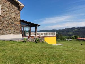 un edificio de piedra con porche en un campo de césped en Casa rural con piscina, Cedeira, San Román en Cedeira