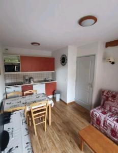 een keuken en een woonkamer met een tafel en een bank bij Le hameau des écrins in Narreyroux