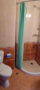 a bathroom with a toilet and a shower with a blue shower curtain at Hotel 415 in Sunny Beach