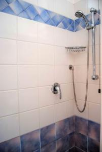 um chuveiro numa casa de banho com azulejos azuis e brancos em Hotel Ardesia em Rimini