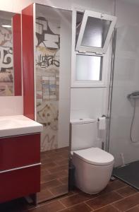een badkamer met een toilet, een wastafel en een raam bij PLAYA DEL PALO, MIRAMAR in Málaga