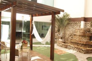 a patio with a hammock in a house at Turis Hotel Centro in Campo Grande