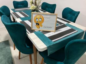 een tafel met blauwe stoelen en een foto erop bij Private house in Vaslui