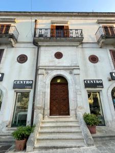 a building with a large wooden door and stairs at Dimora alla Villa in Ostuni
