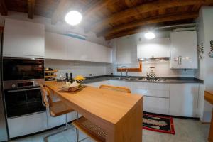 una cocina con mesa de madera y sillas. en Alilandia - Casa Vacanza, en Valdobbiadene