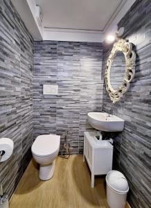 La salle de bains est pourvue de toilettes, d'un lavabo et d'un miroir. dans l'établissement Pensiero Romano, à Rome