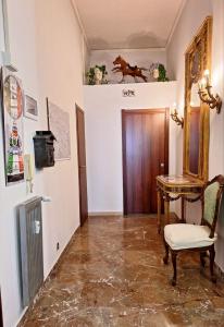 un couloir avec une chaise, une table et une porte dans l'établissement Pensiero Romano, à Rome