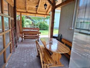 Una mesa de madera y bancos en un patio. en Vila ETIJA, en Veľký Meder