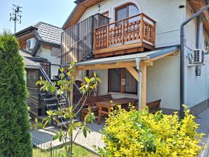 Casa con balcón y mesa de madera en Vila ETIJA, en Veľký Meder