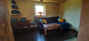 - un salon avec un canapé bleu et une table dans l'établissement Ekologiczny Domek , Pojezierze Drawskie, à Biały Bór
