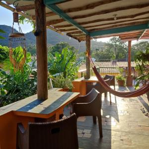 eine Terrasse mit einer Hängematte sowie Tischen und Stühlen in der Unterkunft Casaione in Puerto Colombia