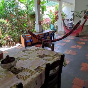 Puerto Colombia的住宿－Casaione，植物间里一张桌子和吊床