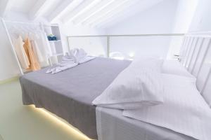a white bedroom with a bed with white sheets at LA CASA DI MARCONI in Symi