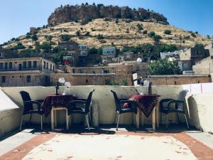 a table and chairs on a balcony with a mountain at Rosa Hostel in Mardin
