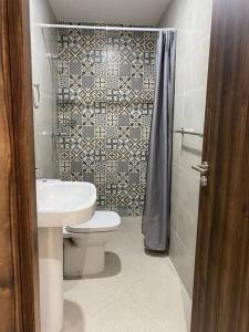 y baño con aseo, lavabo y ducha. en sea view villa with garden, en Agadir