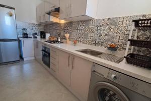 a kitchen with white cabinets and a washer at sea view villa with garden in Agadir