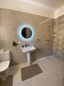 W łazience znajduje się umywalka, toaleta i lustro. w obiekcie sea view villa with garden w mieście Agadir
