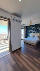 a bedroom with a bed and a sliding glass door at sea view villa with garden in Agadir