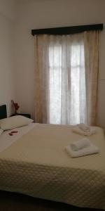 a bed with two towels on it in front of a window at 5bedroom villa in perissa beach in Perissa +37 photos