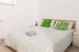 a bedroom with a bed with green and white pillows at Staurenghi Green Apartment in Varese