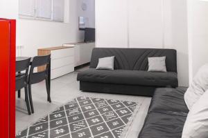 a living room with a black couch and a table at Staurenghi Green Apartment in Varese