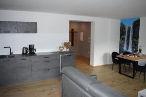uma cozinha e sala de estar com um sofá e uma mesa em Residence Ladurn em Tirolo