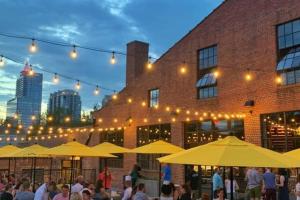 a group of people sitting under umbrellas in front of a building at Hargett Street House in Raleigh