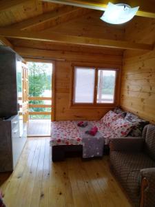 een kamer met een bed en een bank in een hut bij Slatka Drina in Lazarevići