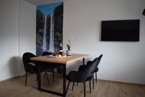 uma mesa de jantar e cadeiras com uma pintura de cascata na parede em Residence Ladurn em Tirolo