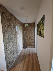 un couloir vide avec une fresque murale et du parquet. dans l'établissement Apartment mit Balkon, perfekt als Monteurwohnung oder Stundentenwohnung, à Springe