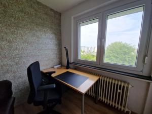un bureau avec un bureau, une fenêtre et une chaise dans l'établissement Apartment mit Balkon, perfekt als Monteurwohnung oder Stundentenwohnung, à Springe