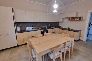 a large kitchen with a wooden table and chairs at Villa Katy in Tormine
