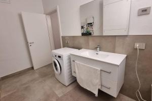 a bathroom with a washing machine and a sink at Villa Katy in Tormine +10 photos
