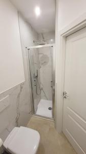 uma casa de banho branca com um chuveiro e um WC. em Dolomiti 2 rooms Apartment Center WiFi TVsmart AC em Bolzano