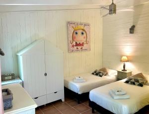 - une chambre avec 2 lits et un tableau mural dans l'établissement La Villa Carcassonne, Cité 8 min à pieds, Clim, Piscine, Full Wifi, Borne 7,5kW, Vélo élect, Parking privé, à Carcassonne