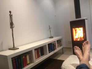a person laying in front of a fireplace with their feet at SweetSuites 40A Lavendelhaus in Mühlhausen