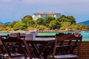 stół i krzesła na patio z widokiem na ocean w obiekcie Bragança's Houses w mieście Cabo Frio