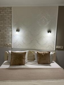 ein großes Bett mit weißer Bettwäsche und Kissen in der Unterkunft Budget Family Hotel in Lwiw