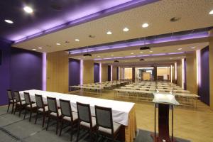 فندق داب في براغ: غرفة كبيرة بها طاولات وكراسي واضاءة ارجوانية