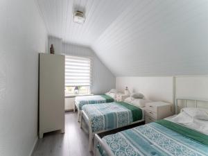 a bedroom with three beds and a window at Comfortable semi-detached holiday home in Vlissingen in Vlissingen