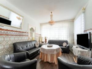 un soggiorno con mobili in pelle e TV di Comfortable semi-detached holiday home in Vlissingen a Vlissingen