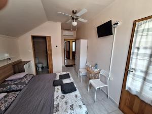 1 dormitorio con 1 cama con ventilador de techo y mesa en Vila ETIJA, en Veľký Meder