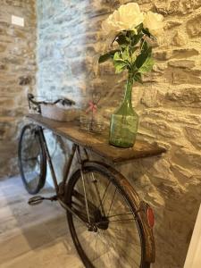 a bike with a vase of flowers on a table at L'oasi delle volpi in Tuoro sul Trasimeno