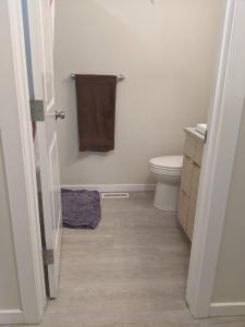 a bathroom with a toilet and a towel at Elmwood stay in Winnipeg