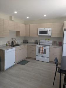 a kitchen with white appliances and wooden cabinets at Elmwood stay in Winnipeg